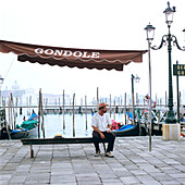 A gondolier sitting on a bench, Venice, Italy