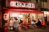 People sitting at a fast food at night, Yurakucho Yakitori Alley, Ginza, Tokyo, Japan