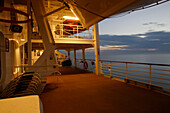 Illuminated deserted deck at sunset, cruise ship MS Delphin Renaissance