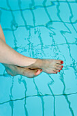 Woman with feet in pool, low section