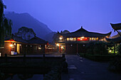 Blick auf Wannian Kloster mit erleuchteten Fenstern am Abend, Emei Shan, Provinz Sichuan, China, Asien
