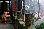 Alter Mönch liest heilige Texte vor einem Pavillon, Wannian Kloster, Emei Shan, Provinz Sichuan, China, Asien