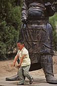 Wächterstatuen, Song Shan,Kind vor Tempelwächter aus Gußeisen im im Vorhof des Kloster Zhongyue, taoistischer Tempel,  Zhongyue, daoistisch-buddhistischer Berg Song Shan, Provinz Henan, China, Asien