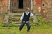 Taichi Meister, Wudang Shan,Taichi Meister, demonstriert Taiji Zyklus vor seinem alten Haus am Fuß des Wudang Shan, daoistischer Berg in der Provinz Hubei, Geburtsort des Taichi, China, Asien, UNESCO Weltkulturerbe