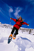 Mann springt in der Luft, Schneeschuhwanderung, Dolomiten, Italien