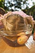 Mädchen steckt ihren Kopf in eine Schüssel mit Wasser, Kindergeburtstag