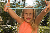 Girl playing cat's cradle, children's birthday party