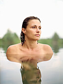 Woman bathing in a lake, mirroring on water surface