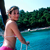 Woman wearing a bikini standing on a sailboat, Dalmatia, Croatia
