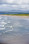 Surfen auf den Rossnowlagh Wellen, gesehen vom Smuggler's Creek Inn, County Donegal, Irland