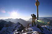 Mann am Zugspitzgipfel im Morgenlicht, Bayern, Deutschland