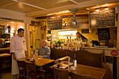 Waiter attending on a guest in the restaurant Weisse Rose (the smallest restaurant of Zurich), Zurich, Canton Zurich, Switzerland