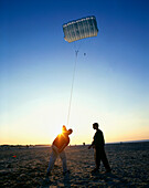 Young men at beach practicing with power kite, Warnemünde, Mecklenburg Vorpommern, Germany
