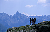 Three hikers with view to Piz dal Teo, Livigno Alps, Oberengadin, Grisons, Switzerland