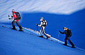 Drei junge Menschen, zwei Frauen und ein Mann, machen eine Skitour in der Region des Skigebietes Parsenn, Davos, Klosters, Graubünden, Graubuenden, Schweiz, Europa, Alpen