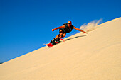 Ein Mann Sandboarding, Tarifa, Andalusien, Spanien, Europa