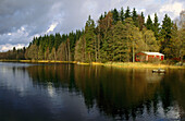 Eine Holzhütte am Ufer eines Sees in Südschweden, Schweden