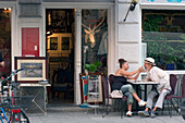Couple sitting in front of a ice cream parlor, Munich, Bavaria, Germany
