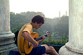 Young man playing guitar, Monopteros, English Garden, Munich, Bavaria, Germany