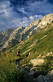 hiker ascending to hut Purtschellerhaus beneath summit of Hoher Göll, Berchtesgaden range, Upper Bavaria, Bavaria, Germany