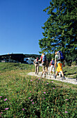 hikers beneath hut Priener Hütte at Geigelstein, Chiemgau, Upper Bavaria, Bavaria, Germany