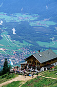 hut Hochgernhaus with hikers resting on the terrace, Chiemgau, Upper Bavaria, Bavaria, Germany