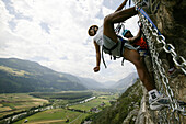 Zwei Männer klettern in Spinnennetz bei Crazy Eddy in Silz, Haiming im Hintergrund, Tirol, Österreich