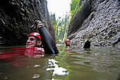 People glinding through river, swim and hike canyon Raebloch, Emmental valley, Canton of Bern, Switzerland, MR