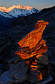 Canton Valais, a cairn at sunrise at the Zwischenbergpass on the way to the Weissmies (4017 m). In the background the fourthausend meter peaks of the Mischabel: Alphubel, Taeschhorn, Dom, Lenzspitze, Nadelhorn, canton Valais,Switzerland, Europe