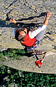 Junge Frau klettert an Felswand, Urner Alpen, Kanton Uri, Schweiz, MR
