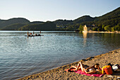 Young couple lying at beach, Lake Fuschl, Fuschl am See, Salzkammergut, Salzburg, Austria