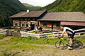 Man on mountain bike passing Rastötzen Alm (1743 m), Bad Hofgastein, Gastein Valley, Salzburg, Austria