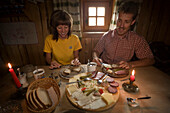 Couple eating a Jause (snack), Karseggalm (1603 m, one of the oldest mountain hut in the valley), Grossarl Valley, Salzburg, Austria
