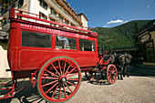 Red carriage of the Mont Cervin Palace parking in front of the Hotel, Zermatt village, Zermatt, Valais, Switzerland