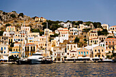 Yacht and sailing boats anchoring at quay of harbor Gialos, Simi, Symi Island, Greece