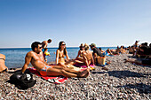 Group of young people sunbathing at Gennadi beach, Gennadi, Rhodes, Greece