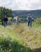 Bicycle trip, couple with son on a bicycle tour, Hotel Muenchhausen in the background, near Hameln, Weserbergland, Lower Saxony, Germany
