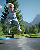 Junge hüpft auf Trampolin, Simmental, Berner Alpen, Kanton Bern, Schweiz