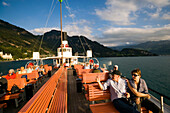 Passengers sitting on deck of a paddle wheel steamer, Lake Lucerne, Canton of Lucerne, Switzerland