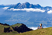 Three people on Rigi Kulm (1797 m) enjoying view over Lake Lucerne to Pilatus (2132 m), Rigi Kulm, Canton of Schwyz, Switzerland
