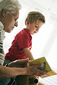 Grandmother and grandchild reading a book together