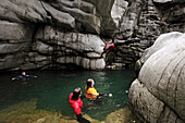 A group of people swims through the Maggia Canyon, Valle Maggia, Tessin, South Switzerland