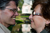 Älteres Ehepaar lächelt sich an, Schloß Benrath, Düsseldorf, Landeshauptstadt von NRW, Nordrhein-Westfalen, Deutschland