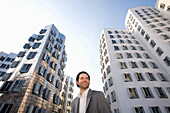 Junger Geschäftsmann vor Neuer Zollhof, Architektur von Frank O.Gehry, Medienhafen in Düsseldorf, Nordrhein-Westfalen, Landeshauptstadt in NRW, Deutschland