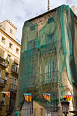 dilapidated house covered in nets to prevent falling bits, Valencia, Spain
