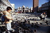 Child and pigeons on Piazza San Marco, Venice, Italy