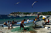 Fishermen cleaning the fishing nets, Playa Municipial, Puerto Escondido, Oaxaca, Mexico, America