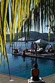 Woman sitting by the pool, Pool area, Luxury hotel, La Casa que canta Zihuatanejo, Mexico, America