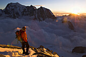 Mountaineer on mount Dent du Greant, Mont Blanc in background, France, Italy