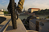 Young man on trial bike riding along edge of a wall, Linz, Upper Austria, Austria